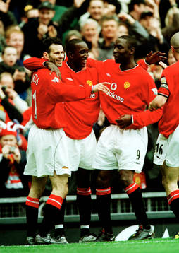 Tvåmålskytten Dwight Yorke gratuleras av Ryan Giggs och
