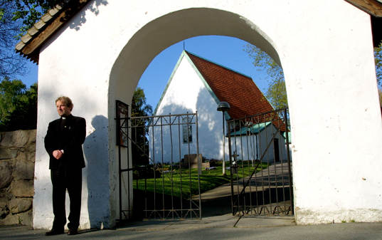 Häckenpräst framför Lundby gamla kyrka. präst