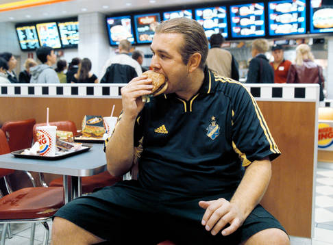 Kjell Evstigen, supporter äter hamburgare., AIK