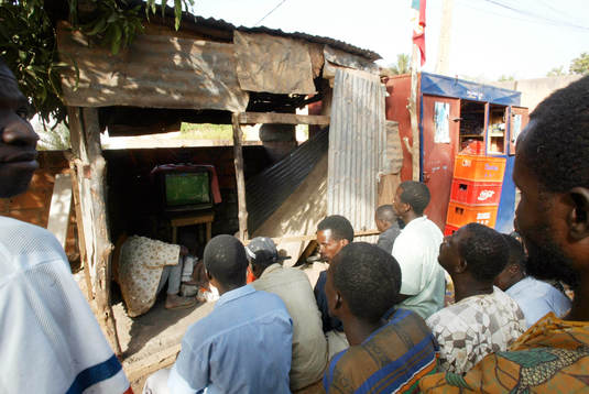TV-tittande ute på gatan i skjul, lite varstans i Bamako.