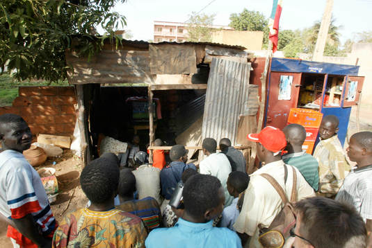 TV-tittande ute på gatan i skjul, lite varstans i Bamako.