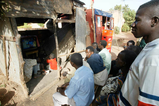TV-tittande ute på gatan i skjul, lite varstans i Bamako.