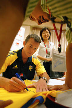 Patrik Andersson, Sverige, skriver en autograf till en