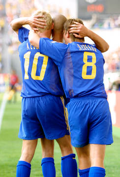 Henrik Larsson gratuleras av Anders Svensson och Marcus