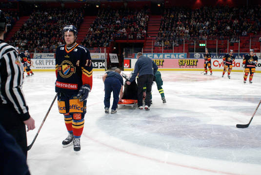 Här bärs domaren Thomas Andersson ut på bår medans
