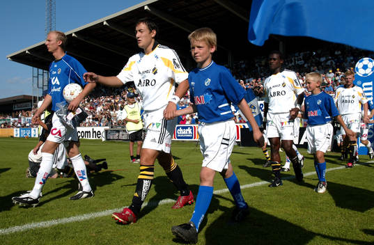 Inmarsch, Stefan Ishizaki. Hand i hand med mascot,