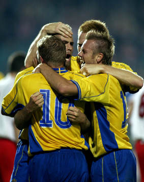 Olof Mellberg gratuleras av Allbäck, Michael Nilsson och