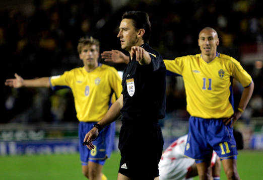 Henrik Larsson och Anders Svensson protesterar när domaren