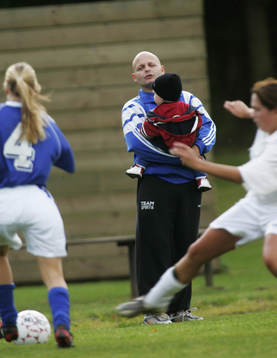 Barnpassning, pappa passar barnet när mamma spelar fotboll