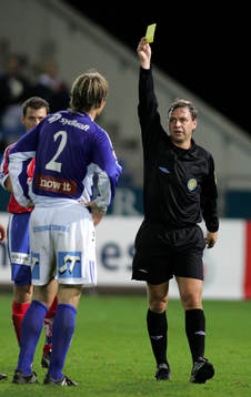 Domare Åke Andreasson delar ut ett gult kort till Karl