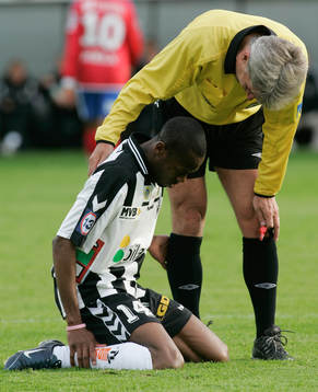 Domaren Peter Fröjdfeldt tittar till skadade Kevin Amuneke