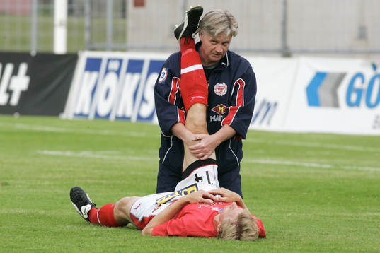 Ola Ragnarsson, hjälper en spelare att stretcha