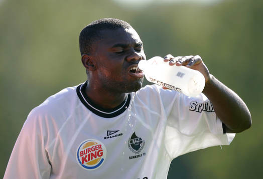 Mike Owusu dricker. Vattenflaska