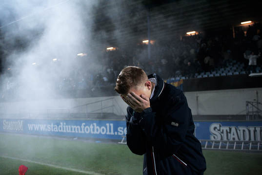 Tårgasattack, tårgas, här skyddar sig en supporter .