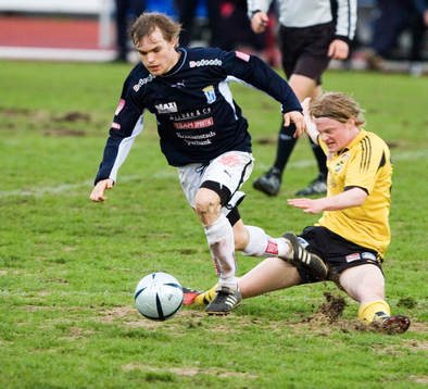 Fredrik "Lillen" Andersson glidtacklas av Mikael Larsson.