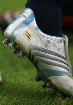 Lionel Messi har en  sko med texten "Guds Hand" (La Mano de