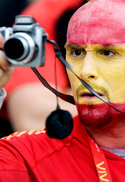 Supporter, fan, från Spanien med kamera. Ansiktsmålning.