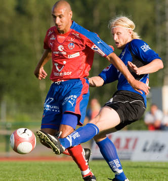 Per Johansson sparkar undan bollen framför Henrik Larsson