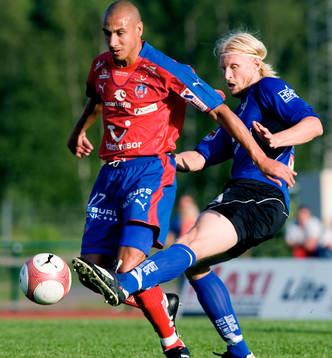 Per Johansson sparkar undan bollen framför Henrik "Henke"
