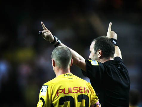 Jonas Eriksson, domare, signalerar och Andreas Augustsson,