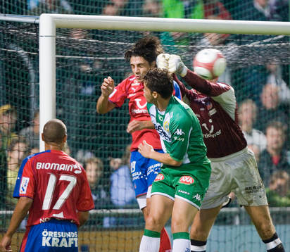 Daniel Andersson boxar bort bollen framför Paulinho Guara
