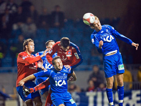 Marco Vasilj nickar undan framför en hel hög spelare som