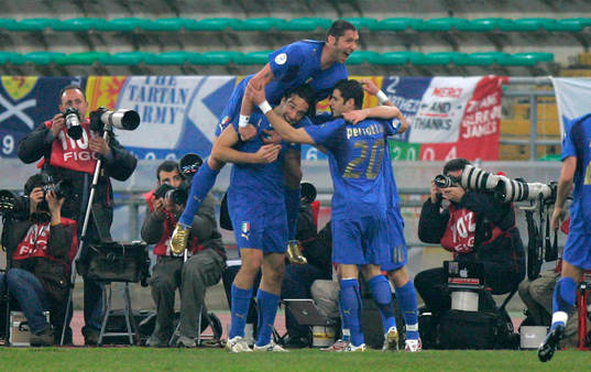 Luca Toni gratuleras av  Marco Materazzi och Simone