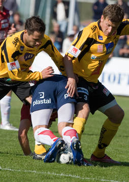 Två Mjällby-spelare tar en Örgryte-spelare bakifrån
