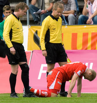 Domare. Spelare på knä,skada, skadad