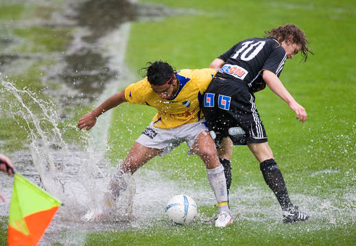 Planen var inte i skick för fotboll, här kamp om bollen i