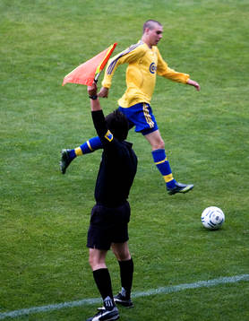 Offside, assisterande domare vinkar offside på en spelare.
