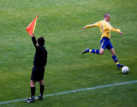 Offside, assisterande domare vinkar offside på en spelare.