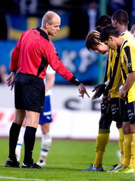 Patrik Berglund, domare, visar muren vart