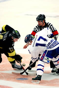 Domaren Patrik Sjöberg släpper pucken till AIK:s Fredrik