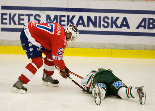 Jens Karlsson och en liggande Rögle-spelare
