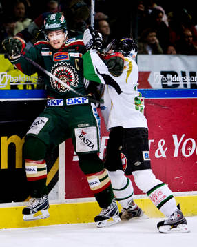 Jonas Johnson, Frölunda, trycks upp i sargen av Dominik