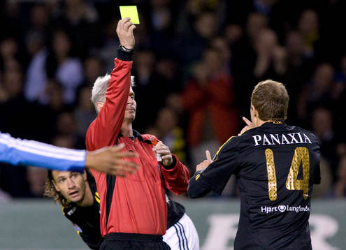 Peter Fröjdfeldt, domare ger Kenny Pavey, AIK gult kort,