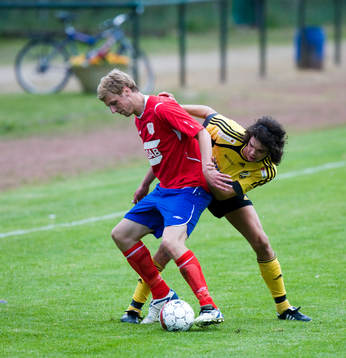 Filip Thurn försöker stoppa en Bälinge-spelare