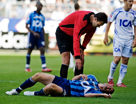 Martin Ingvarsson, domare, räcker sig över en skadad