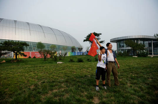 Familjer tar bilder utanför Tianjin Olympic Center Stadium
