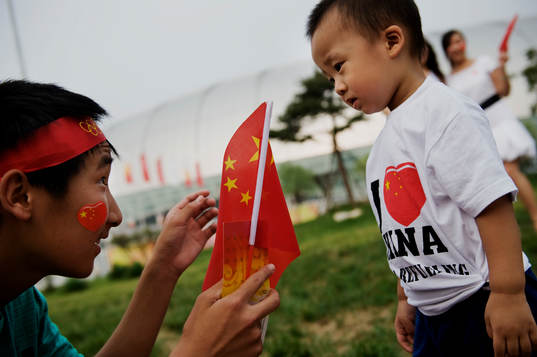 Familjer tar bilder utanför Tianjin Olympic Center Stadium