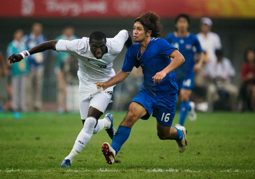 Takuya Honda, Japan, drar i tröjan på Jozy Altidore, USA