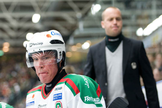 Kenny Jönsson sammanbiten, bakom coachen Peter Johansson
