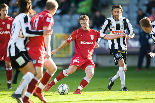 Göran Marklund laddar omgiven av många spelare