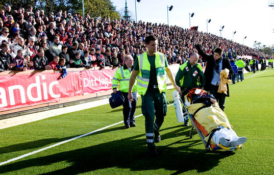 Läkare rullar ut en skadad på bår