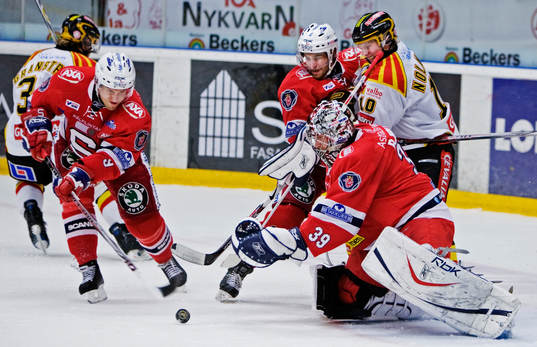 Topi Jaakola rensar undan en puck framför Björn Bjurling,