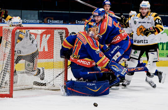 Pucken ligger fri framför Gustaf Wesslau, målvakt,