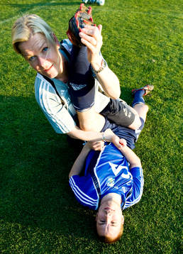 Stina Hedin, sjukgymnast tänjer Kalle Svenssons ben,