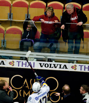 Timråsupportrar skriker och kastar saker på HV71-spelarna
