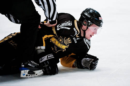 Johan Adolfsson, AIK, trycks ner i isen av en domare